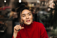 beautiful-brown-eyed-woman-big-gold-earrings-red-outfit-posing-thoughtfully-with-pen-her-hands.jpg